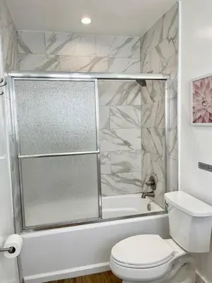 a white bathroom with a shower and a toilet at Serene Studio W Parking 10 min from Beach and FLL in Hollywood