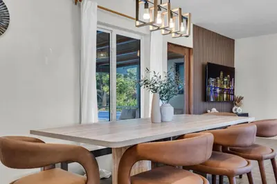 a dining room with a large wooden table and chairs at Pickleball fun Family home near Hard Rock Stadium in North Miami