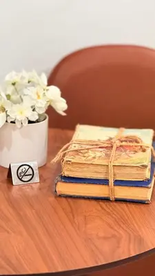 two old books on a table with a vase of flowers at Apartament Miami Design District in Miami