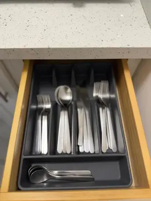 a drawer filled with silver utensils in a cabinet at Apartament Miami Design District in Miami