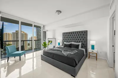 a bedroom with a large bed and a blue chair at Magnificent Unit with Priceless Views W Icon in Miami