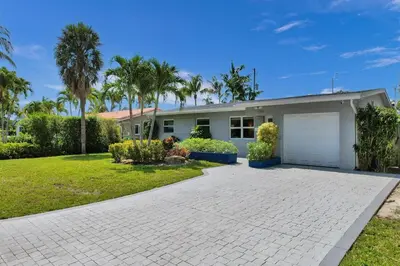 a house with a driveway and a garage at The Zen Den - Heated pool - One mile to heart of The Drive in Fort Lauderdale