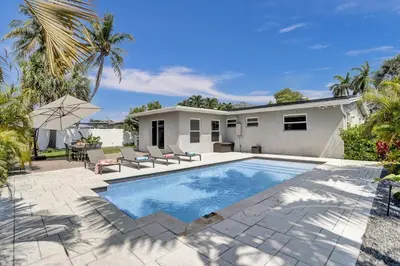 a swimming pool in front of a house at The Zen Den - Heated pool - One mile to heart of The Drive in Fort Lauderdale
