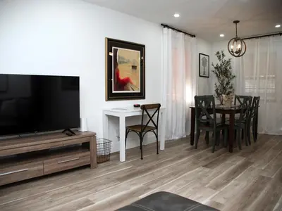 a living room with a tv and a table and chairs at Welcome to Miami Springs Charm in Miami