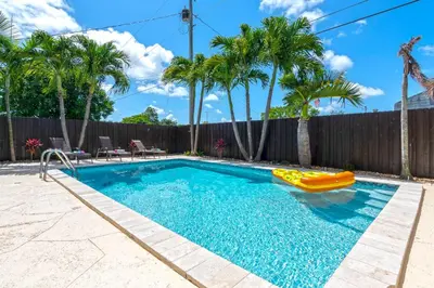 a swimming pool with a slide and an inflatable raft at Tropical house Miami in Cutler Bay
