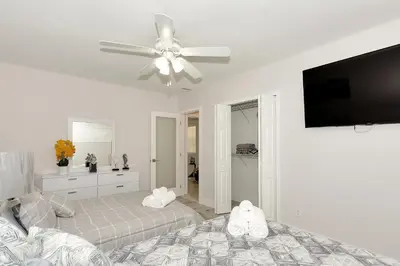 a white bedroom with a ceiling fan and a bed at Tropical house Miami in Cutler Bay