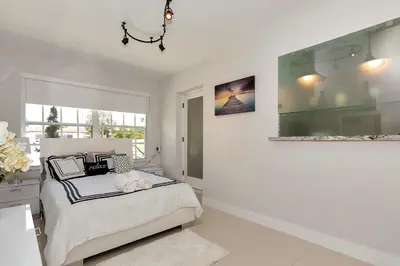a white bedroom with a bed and a window at Tropical house Miami in Cutler Bay