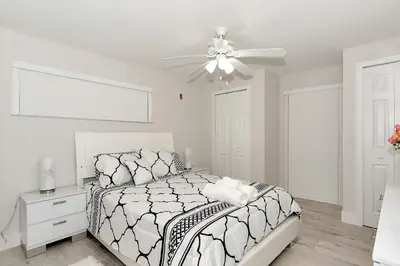 a white bedroom with a bed and a ceiling fan at Tropical house Miami in Cutler Bay