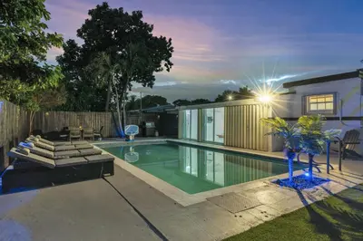 a swimming pool in a backyard with a house at Cozy Miami Private Pool House W- Arcade Games, BBQ in Norland
