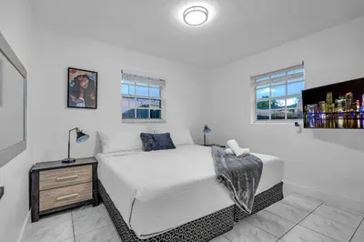 a white bedroom with a bed and two windows at Cozy Miami Private Pool House W- Arcade Games, BBQ in Norland