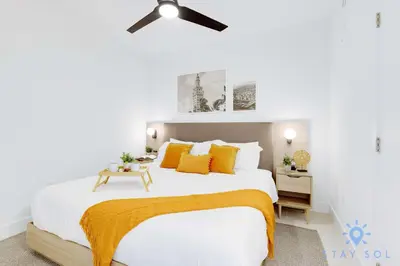 a white bedroom with a large bed with yellow pillows at Great Studio Pool Gym & Views in Miami