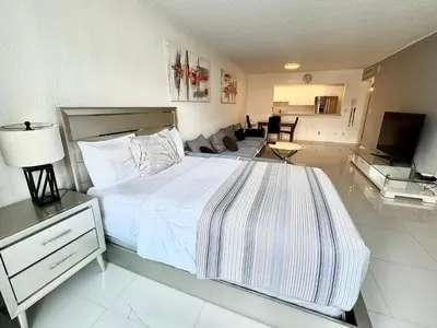 a white bedroom with a bed and a living room at Luxury Ocean Reserve Condo Pool, Gym & Beach Access in Sunny Isles Beach