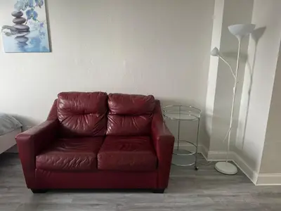 a red leather couch in a living room with a lamp at Luxury Ocean Reserve Condo Pool, Gym & Beach Access in Sunny Isles Beach