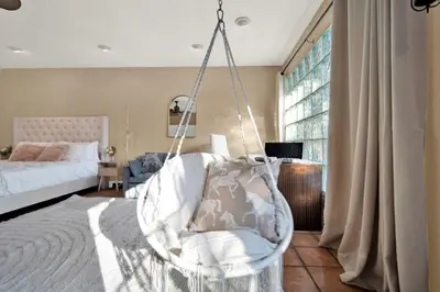a bedroom with a swing chair in a room with a bed at HUGE Outdoor soccer 4BR HEATED Pool house near Las Olas in Fort Lauderdale