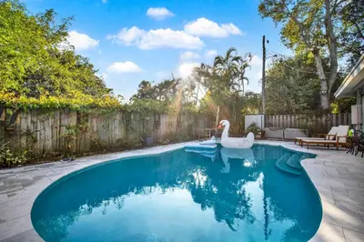 a swimming pool with a swan in a backyard at HUGE Outdoor soccer 4BR HEATED Pool house near Las Olas in Fort Lauderdale