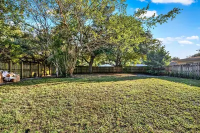 a yard with a fence and a tree at HUGE Outdoor soccer 4BR HEATED Pool house near Las Olas in Fort Lauderdale