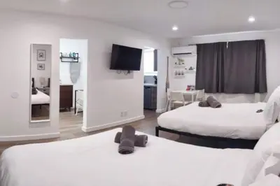 a hotel room with two beds and a flat screen tv at Charming DBL W pool and parking 15 min to FLL and Beach in Hollywood