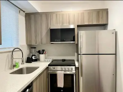 a kitchen with a stainless steel refrigerator and a sink at Modern in heart of Hollywood in Hollywood