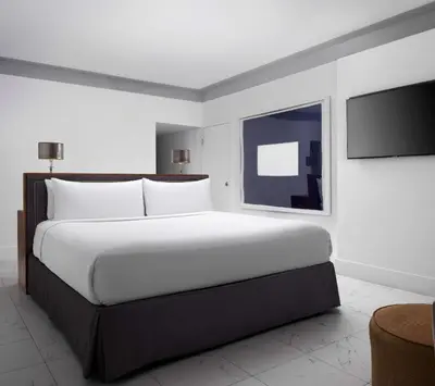 a bedroom with a large white bed and a tv at Nautilus Sonesta Miami Beach in Miami Beach