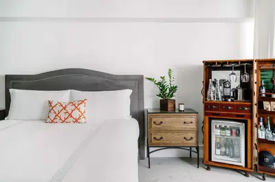 a bedroom with a bed and a wooden dresser at Nautilus Sonesta Miami Beach in Miami Beach
