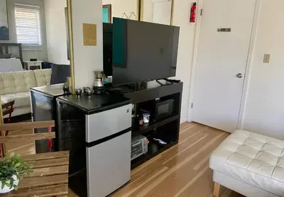a living room with a flat screen tv on a entertainment center at Beautiful suite in the best location in Miami! in Miami