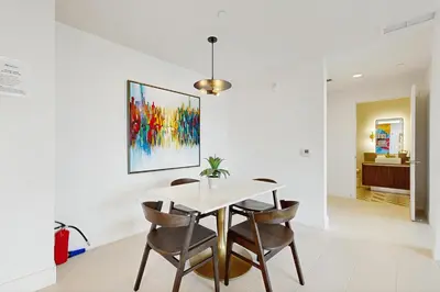 a dining room with a table and chairs and a painting at Beachside Bliss Estate 4801 in Miami