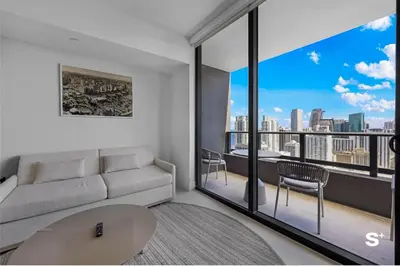 a living room with a couch and a large window at Downtown 1-BD Condo with City Views in Miami