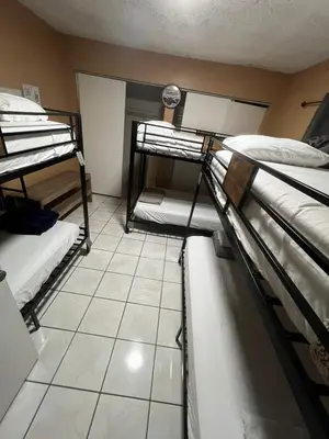 a room with three bunk beds and a tiled floor at Bed in 6-Bed Dormitory Room in Miami