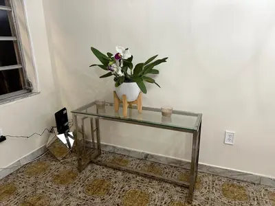 a glass table with a vase of flowers on it at Bed in 6-Bed Dormitory Room in Miami