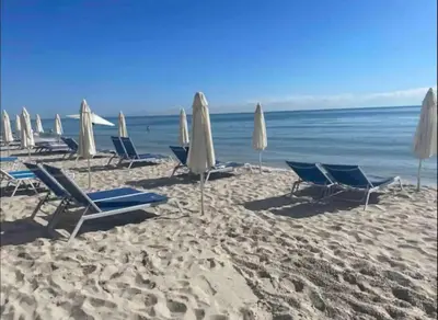 a group of chairs and umbrellas on a beach at Beautiful Hyde Resort Luxe 2BR Private Beachfront in Hollywood