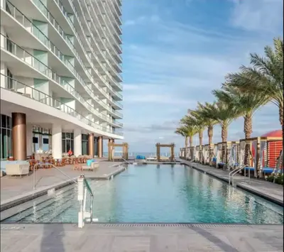 a swimming pool with palm trees and a building at Beautiful Hyde Resort Luxe 2BR Private Beachfront in Hollywood