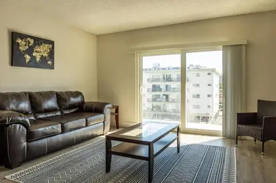 a living room with a leather couch and a glass table at 1BR with Kitchen Eastern Shores near Sunny Isles in North Miami Beach
