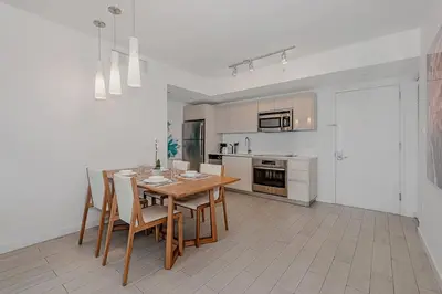 a kitchen with a table and chairs in a room at 1 Bedroom & Kitchen at Beachwalk Luxe Pool - Gym in Hallandale Beach