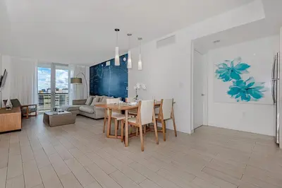 a living room with a table and a couch at 2 Bed 2 Bath at Beachwalk With Pool Gym Beach in Hallandale Beach