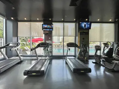 a gym with treadmills and ellipticals in a room at Amazing Studio in Beachwalk with Pool and Beach in Hallandale Beach