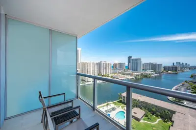 an apartment balcony with a view of the water at Amazing Studio in Beachwalk with Pool and Beach in Hallandale Beach