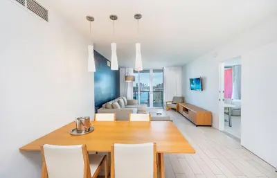 a dining room and living room with a table and chairs at Beachwalk 2 Bedrooms & Kitchen in Hallandale Beach