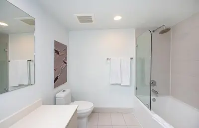 a white bathroom with a toilet and a shower at Beachwalk 2 Bedrooms & Kitchen in Hallandale Beach
