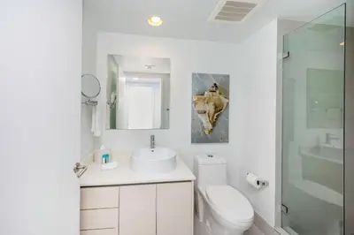 a white bathroom with a sink and a toilet at Beachwalk 2 Bedrooms & Kitchen in Hallandale Beach