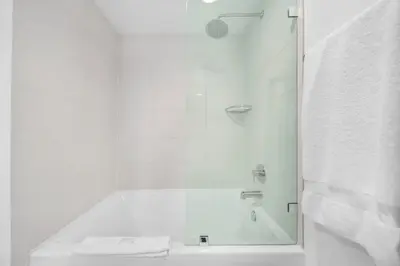 a shower with a glass door next to a sink at 2 Bed 2 Bath Penthouse Amazing Views Beach Service in Hallandale Beach