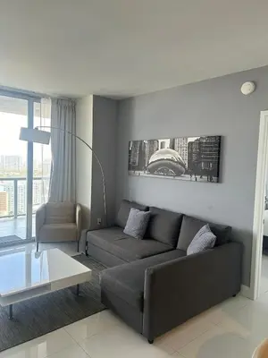a living room with a couch and a table at 2 Bed 2 Bath Penthouse Amazing Views Beach Service in Hallandale Beach