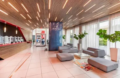 a lobby with couches and chairs in a building at Amazing Studio at Beachwalk with Pool & Gym in Hallandale Beach