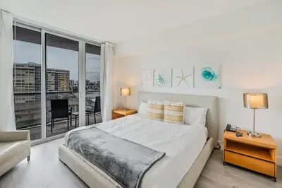 a bedroom with a large bed and a large window at 1 Bedroom w Kitchen on Beachwalk Beach &Pool &Gym in Hallandale Beach