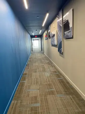 a long hallway with blue walls and a wooden floor at 1 Bed & Kitchen at Beachwalk - Pool Gym Beach 22fl in Hallandale Beach
