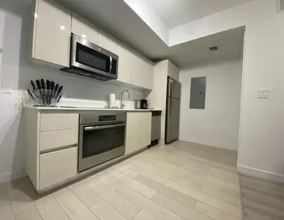 a kitchen with a stove and a microwave at 1 Bed & Kitchen at Beachwalk - Pool Gym Beach 22fl in Hallandale Beach