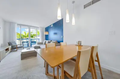 a dining room with a table and a couch at 1 Bed & Kitchen at Beachwalk Luxe Pool Gym Beach in Hallandale Beach