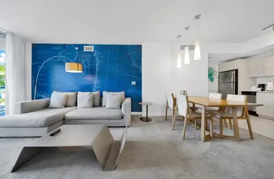 a living room with a couch and a table at 1 Bed & Kitchen at Beachwalk Luxe Pool Gym Beach in Hallandale Beach