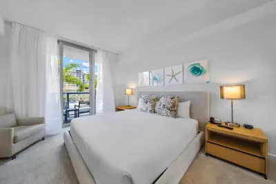a white bedroom with a large bed and a window at 2 Bed & 2 Bath at Beachwalk Pool Gym Beach on 19th in Hallandale Beach