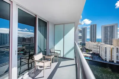 a balcony with two chairs and a view of the city at 2 Bed & 2 Bath at Beachwalk Pool Gym Beach on 19th in Hallandale Beach