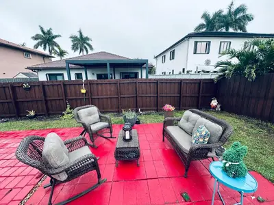 a patio with couches and chairs on a red blanket at Lujosa Y Acogedora Casa En Miami! in Tamiami